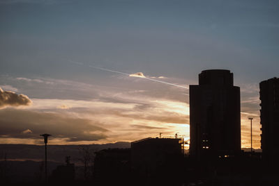 Silhouette buildings against sky during sunset