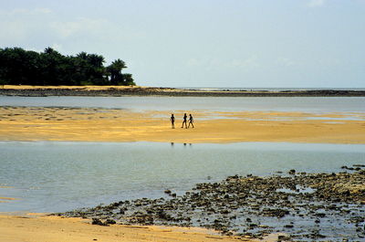 People at beach against sky