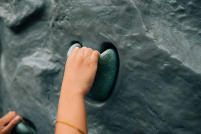 Cropped hand of person climbing wall