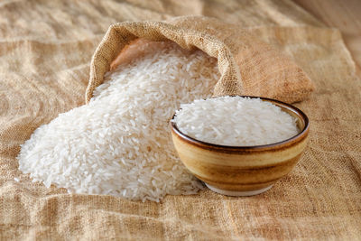 Close-up of bowl and sack with rice