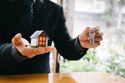 Midsection of man holding hands on table