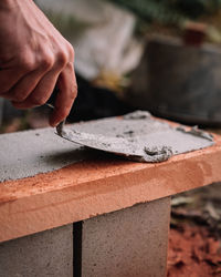 Cropped hand of person working at construction site