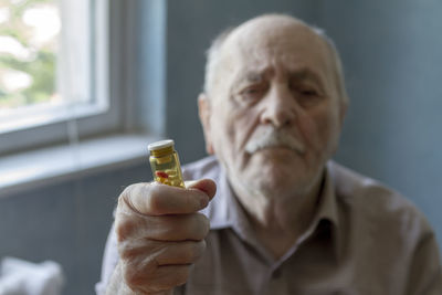 Portrait of man holding bottle of pills