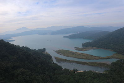 Scenic view of river and mountains against sky