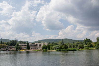 Scenic view of lake by buildings against sky