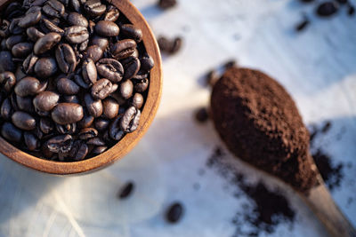 Still life with coffee beans, ground coffee, coffee grinder, wooden spoon, coffee pot, scoop,