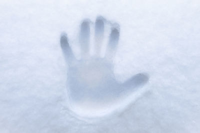 Close-up of human hand on snow
