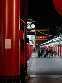 People walking on illuminated street at night