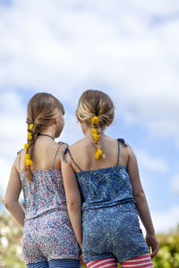 Two girls with dandelion flowers in braids