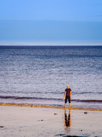 Man standing on beach against clear sky