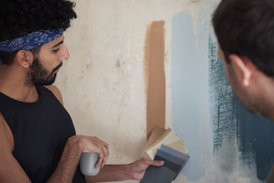 Gay couple renovating flat and choosing wall paint