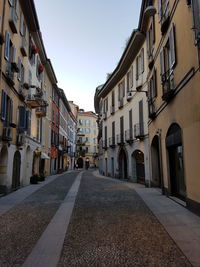 Surface level of road amidst buildings against sky