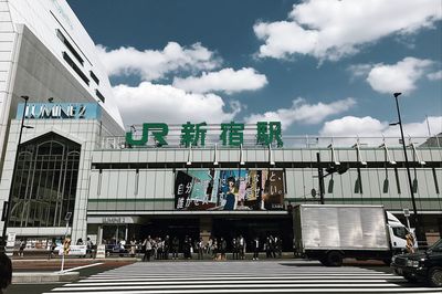 People on road against sky in city
