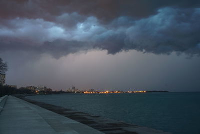 City by sea against storm clouds