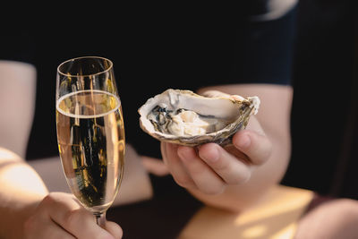 An oyster and a glass of champagne in the hand