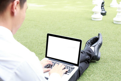 Midsection of man using mobile phone on table