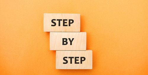 Wooden blocks with the words step by step. business growth and strategy concept.