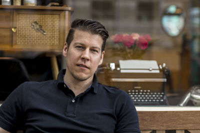 Close-up portrait of mature man sitting on bench