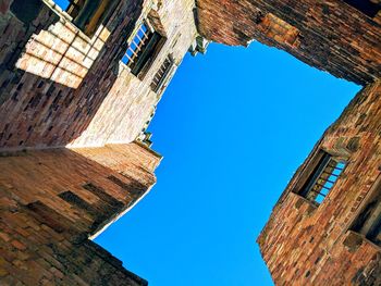 Low angle view of old building against clear blue sky