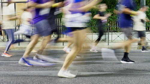 Low section of people walking on road