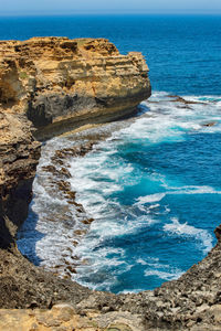 Rock formation on sea shore against sky