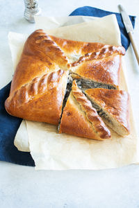 Freshly baked meat pie on a parchment paper on table background. pie with meat and mushrooms. 