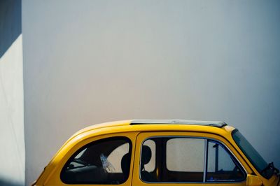 Yellow car against building