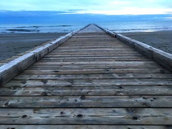 Close-up of wooden boardwalk against sky