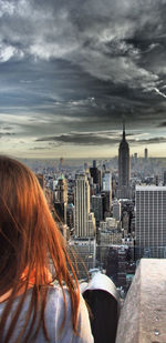 Rear view of red-haired woman looking at new york city buildings