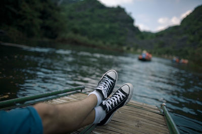 Low section of man on pier over lake