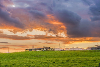 Scenic view of agricultural field against dramatic sky