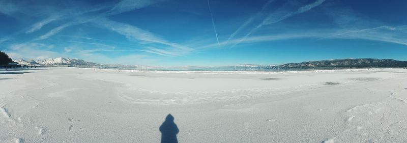 Low section of person on beach against sky during winter