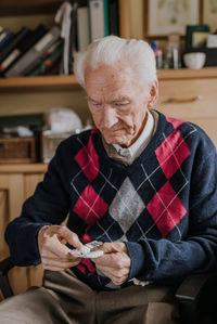 Senior man holding medicine at home