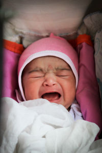 Portrait of cute baby girl sleeping on bed at home