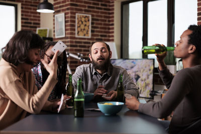 Portrait of smiling friends sitting on table