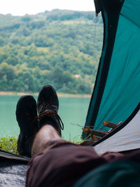 Low section of man relaxing in tent