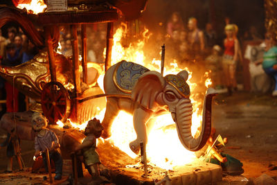 Elephant statue burning on road at night