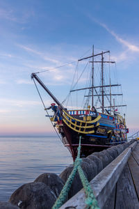Fishing boat moored in sea against sky