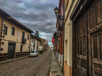 Buildings in city against cloudy sky