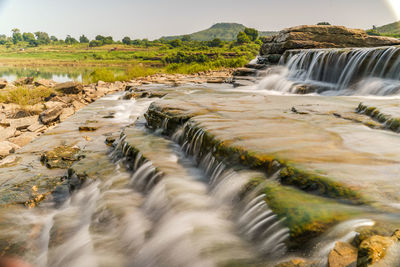 Scenic view of waterfall against sky