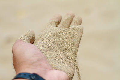 Close-up of hand holding sand