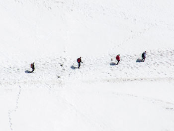 People skiing on snow covered landscape