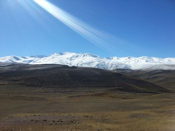 Scenic view of snowcapped mountains against blue sky