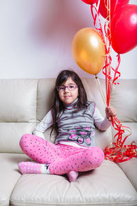 Portrait of smiling girl sitting at home