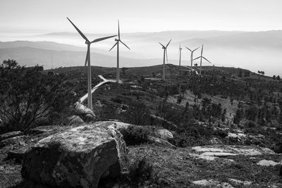 Wind turbines on mountain against sky