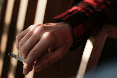 Cropped hand holding burnt cigarette