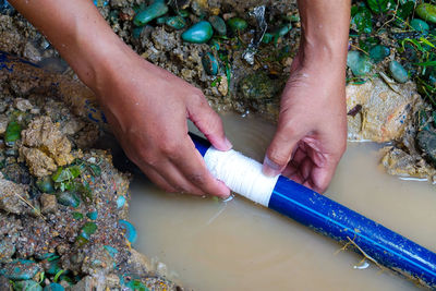 High angle view of man repairing pipe in water