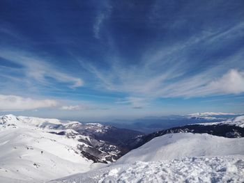 Scenic view of snowcapped mountains against blue sky