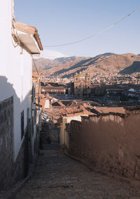 Alley amidst buildings in town against clear sky