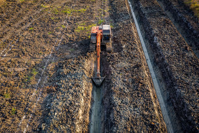 High angle view backhoe is dingging the groove garden and agricultural area evening time in thailand